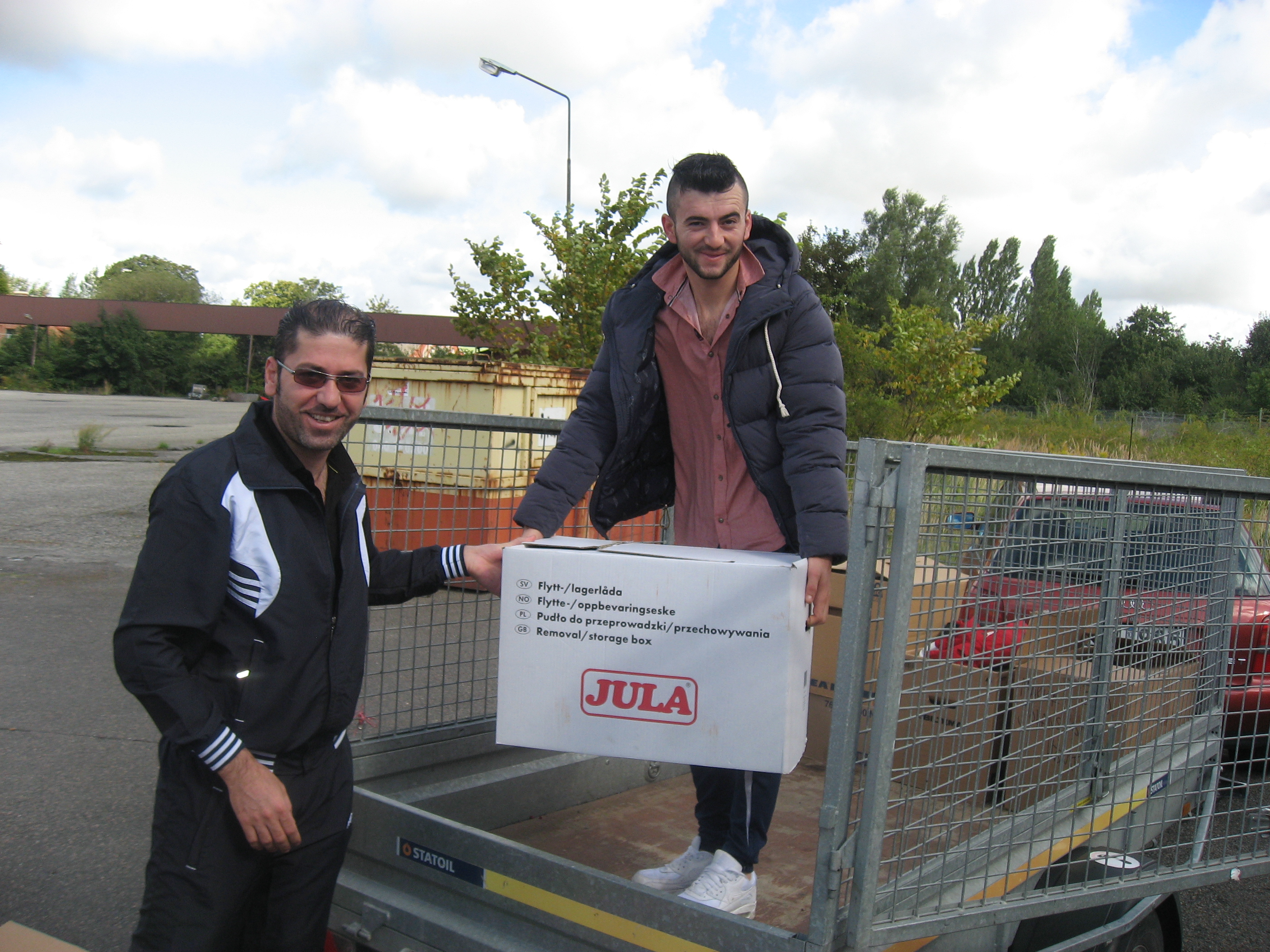 Nashwan Mirza t.v. och Kovan Kotchab hjälps åt att last kartongerna med klädesplagg för transport till Irak.