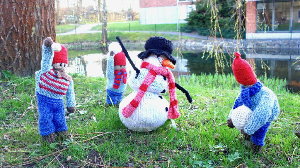 Vid dammen står dessa trevlig figurer som påminner oss om de kalla vintermånader som just har lämnat oss. Figurerna föreställer en snögubbe och tre barn i form av stickade kläder som fyllts för att ge rätt form. Foto: Leif Persson